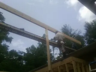 Carpenter setting a ridge beam over a new addition frame — Ice Dam Removal by Roofing Brothers in Rocklin